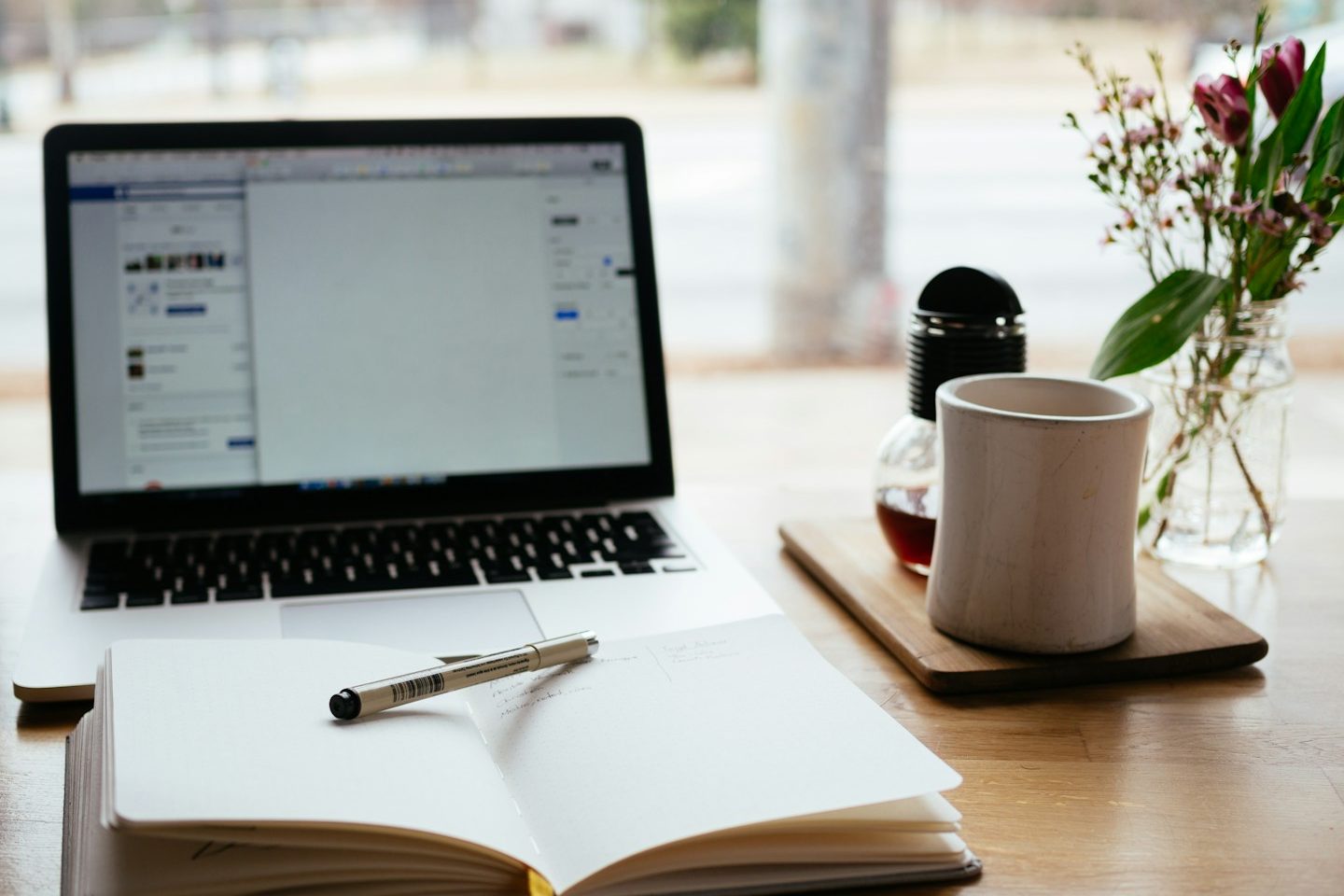 Lebensberatung mit Tiefe: Schreibtisch mit Notizbuch, Kaffee, Blume und Laptop–Symbol für Klarheit, Orientierung und  Persönliche Entwicklun